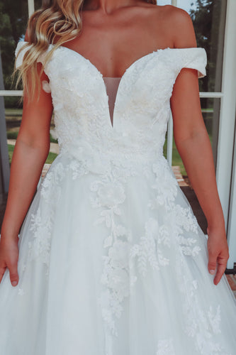 In a fairytale off the shoulder bridal gown
